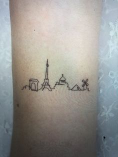 a small tattoo on the ankle of a woman's leg with a city skyline