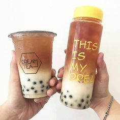 two people holding up cups with bubble tea in them that say, this is my dream