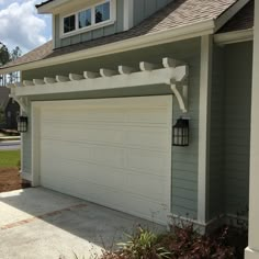 a house with a white garage door and an attached light on the side of it