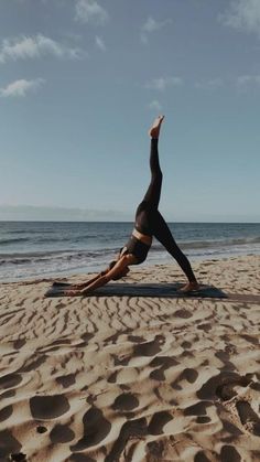 a woman is doing yoga on the beach