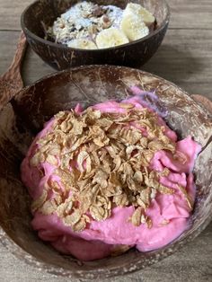 two bowls filled with food on top of a wooden table