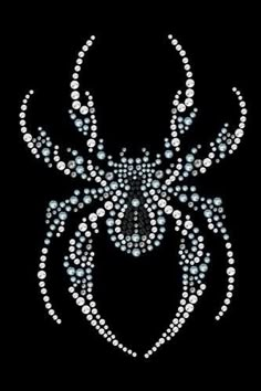 a spider made up of white and blue beads on a black background with the shape of a face