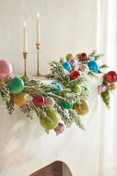 a decorated mantle with candles and ornaments on it