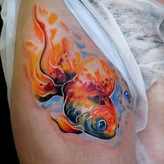 a woman with a tattoo on her stomach has a goldfish painted on it's side