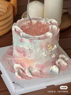 a pink and white cake sitting on top of a table