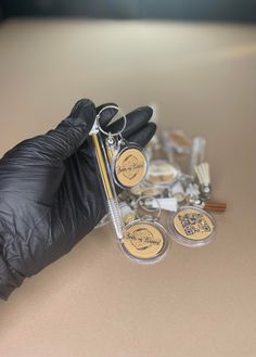 a pair of black gloves is holding some metal scissors and other items on a table