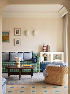 a living room filled with furniture and pictures hanging on the wall above it's windows