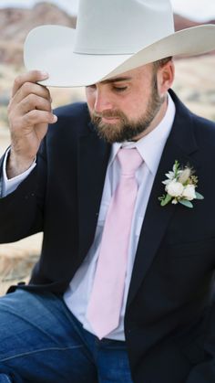 a man wearing a white cowboy hat and pink tie