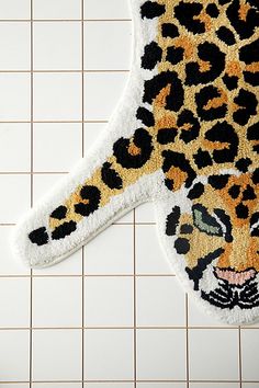 an animal rug is laying on the floor next to a tiled wall with white tiles