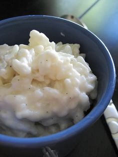 a blue bowl filled with mashed potatoes on top of a table