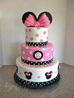 a three tiered cake decorated with minnie mouse ears