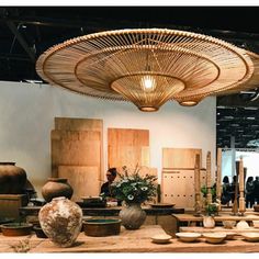 a room filled with lots of vases and other items on display in front of people