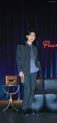 a young man standing in front of a couch