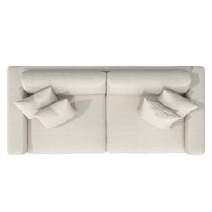 two white couches with pillows on top of each one in front of a white background