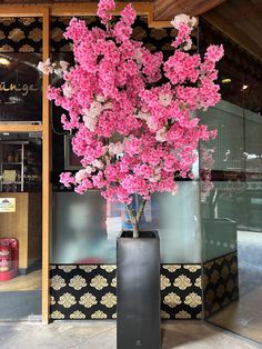 a vase with pink flowers in front of a store