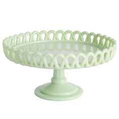 a white cake plate with wavy design on the top and bottom, sitting on a pedestal