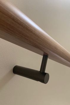 a close up view of a wooden handle on a wall mounted shelf in a room