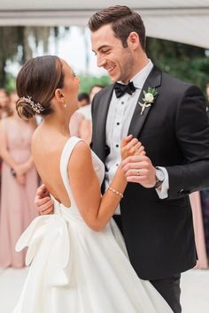 a bride and groom are dancing together at their wedding reception in front of an audience