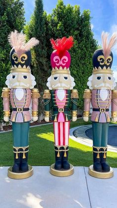 three wooden nutcrackers are standing in the grass