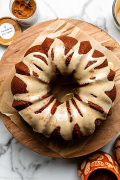 a bundt cake sitting on top of a wooden cutting board next to some spices