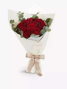 a bouquet of red roses wrapped in white paper