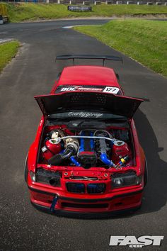 a red car with its hood open and the engine in it's trunk is shown