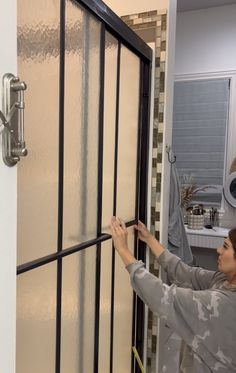 a woman is working on a glass door