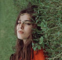 a woman with her eyes closed standing in the grass