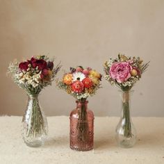 three vases filled with different types of flowers