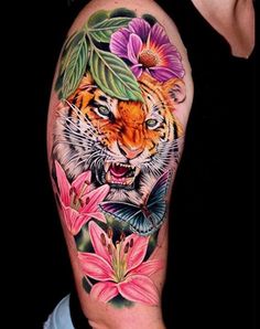 a tiger with flowers and leaves on his arm