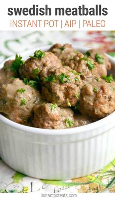 a white bowl filled with meatballs on top of a floral tablecloth covered table