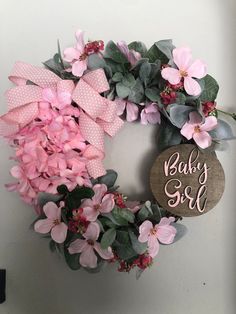 a baby girl wreath with pink flowers and greenery