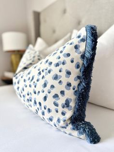 a white bed topped with blue and white pillows