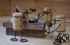 three wine corks are sitting on top of a wooden table with glasses and bottles