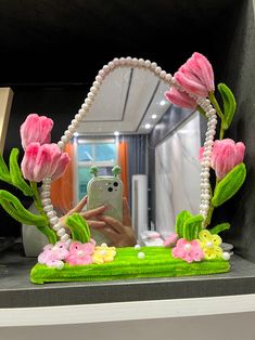 a woman taking a selfie in front of a mirror with pink flowers on it