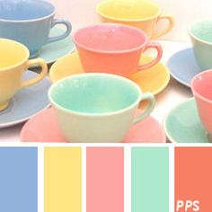 there are many different colored cups and saucers on this table with the same color scheme