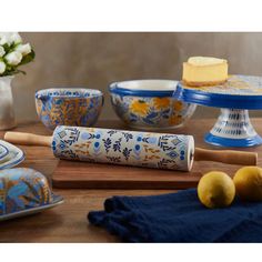 a wooden table topped with blue and white bowls filled with cake next to lemons