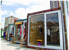 there are many different types of clothing on display in the store window and behind it is a sign that says, what pop - up?