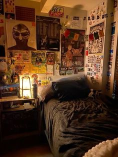 a bed sitting in a bedroom next to a wall covered with posters and pictures on it