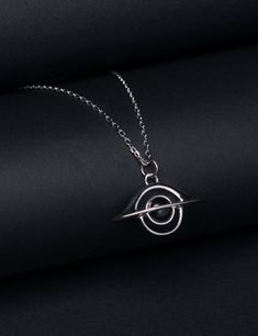 Featuring a black hole, this exquisite necklace is designed to honor Andrea Ghez, who was awarded the 2020 Nobel Prize in Physics for discovering the supermassive black hole that lurks at the center of the Milky Way. A Black hole is a great amount of matter packed into a very small area - think of a star ten times more massive than the Sun squeezed into a sphere approximately the diameter of New York City. The result is a gravitational field so strong that nothing, not even light, can escape. Th Physics Jewelry, Spacecore Fashion, Astronomy Necklace, Character Jewelry, Supermassive Black Hole, Astronomy Jewelry, Nobel Prize In Physics, Space Necklace, Astronomy Gift