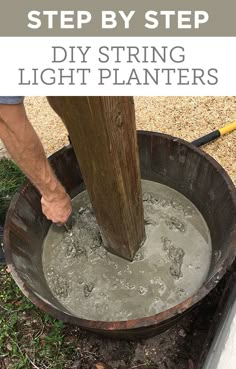 a man is pouring water into a bucket with a wooden pole in the back ground