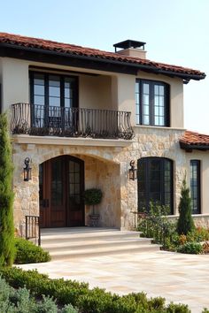 a large stone house with two balconies on the second floor and an attached balcony