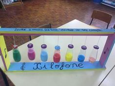 a sign that has some bottles on it with the names of different colored liquids in them