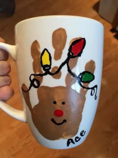 a person holding a coffee mug with handprints on it