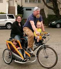 a man, woman and child are riding on a bicycle