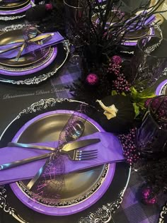 purple plates and silverware on a black table cloth