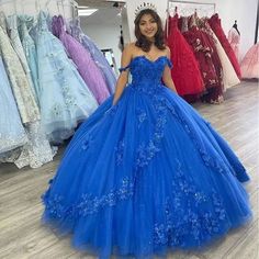 Step into a world of elegance and beauty with the Royal Blue Off-Shoulder Ball Gown with Flowers Tulle Quinceanera Dress. This stunning ball gown is crafted from soft, airy tulle, creating a dreamy, ethereal look that flows gracefully with every movement. The rich royal blue color adds a regal touch, making this dress the perfect choice for your quinceanera or any grand celebration. The off-the-shoulder neckline adds a romantic and feminine appeal, beautifully accentuating your shoulders and nec Royal Blue Quince Dresses Quinceanera, Royal Blue Ball Gown For Quinceanera During Prom Season, Blue Tulle Quinceanera Dress For Gala, Blue Ball Gown For Sweet 16, Fitted Blue Quinceanera Dress For Banquet, Blue Tulle Gown For Sweet 16, Blue Tulle Dress For Sweet 16, Fitted Blue Quinceanera Dress For Sweet 16, Blue Sweetheart Neckline Dress For Sweet 16