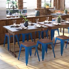 a dining room table set up with chairs and plates on top of the wooden tables