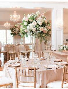 a table set up with white and pink flowers