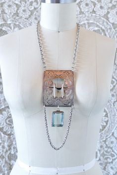 This is one of the most special pieces of jewelry to the shop in a while. Made entirely from repurposed sterling silver components, this necklace centers around a gorgeous antique sterling floral belt buckle. It is set with texture vintage sterling chain, and hanging from the center, a large emerald cut pale blue stone pendant, likely an aquamarine. This piece is full of vintage glamour, a modern day heirloom.  All pieces are unique. They are made completely from found and recycled parts, much like found-object art. I have loved jewelry my whole life. I want to create pieces that drape and lay on the body the way clothing would, using relics and totems from years past. Jewelry you'd see a rockstar wear... Jewelry that requires guts, soul, and thought... www.reckless-daughter.com Floral Belt, Blue Stone Pendant, Buckle Necklace, Silver Wrapping Paper, Tan Leather Jackets, Art Nouveau Pendant, Object Art, Mixed Media Jewelry, Beaded Jacket